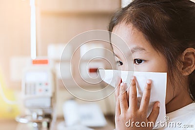 Sick asian child girl wiping and cleaning nose with tissue Stock Photo