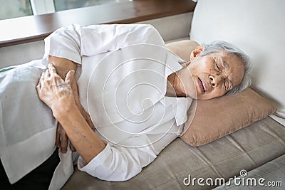 Sick asian senior woman with stomach ache,old people having aching belly,hands touching stomach painful,gastritis,gastric ulcer, Stock Photo