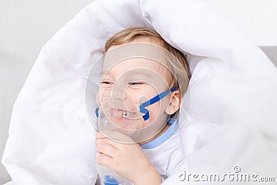 Sick baby boy with inhaler treats throat at home, the concept of health and inhalation treatment Stock Photo