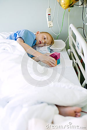 Sick boy in hospital bed with his toy Stock Photo