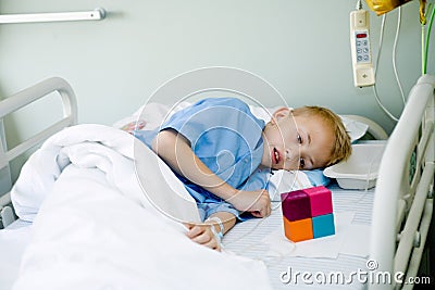 Sick boy in hospital bed with his toy Stock Photo