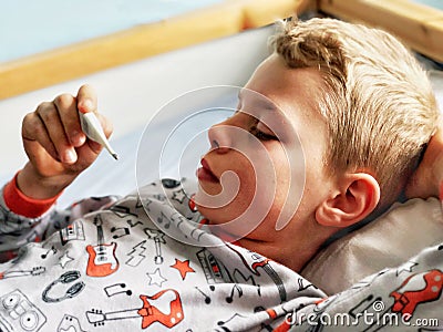 Sick boy taking his temperature Stock Photo