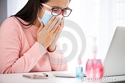 Sick business woman hand taking white tissue paper while cough. Laptop mouse smartphone, sanitizer gel, medical face mask, and Stock Photo