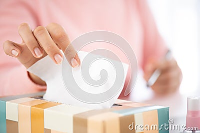 Sick business woman hand taking white tissue paper while cough. Laptop mouse smartphone, sanitizer gel, medical face mask, and Stock Photo