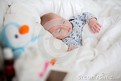 Sick child boy lying in bed with a fever, resting at home Stock Photo