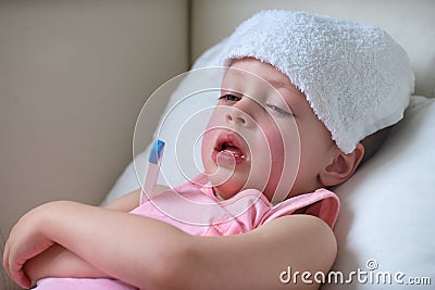 Sick child with high fever laying in bed Stock Photo