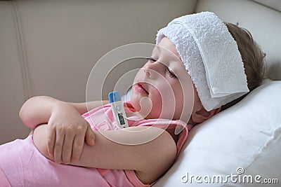 Sick child with high fever laying in bed Stock Photo