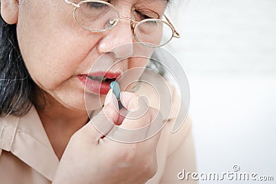 Sick elderly Asian woman Take medications to treat illnesses. Stock Photo