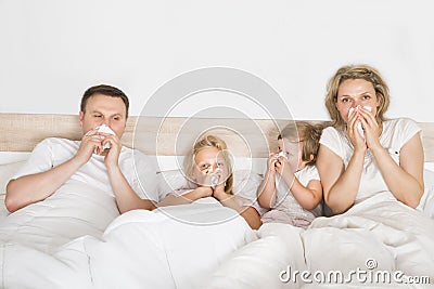 Sick family lying in bed Stock Photo