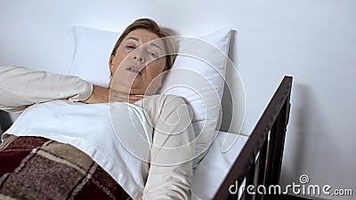 Sick female in bed hardly breathing, suffering suffocation, asthma disease Stock Photo