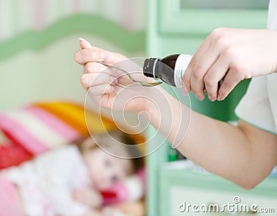 Sick girl awaits her medication pouring in a spoo Stock Photo