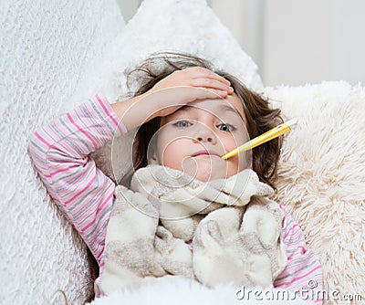 Sick girl lying in bed with a thermometer in mouth and touch his forehead Stock Photo