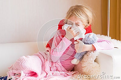 Sick girl with runny nose sitting in sofa Stock Photo