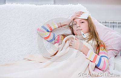 Sick girl with scarf lying on bed Stock Photo