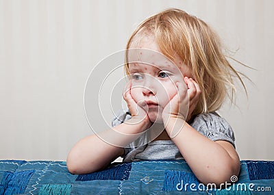 A sick girl is sitting near the bed Stock Photo