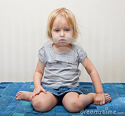 A sick girl is sitting near the bed Stock Photo