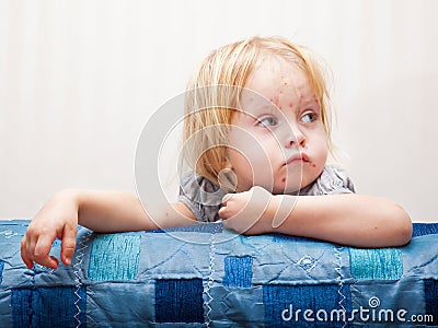 A sick girl is sitting near the bed Stock Photo