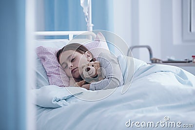 Sick girl sleeping with teddy bear in the hospital Stock Photo