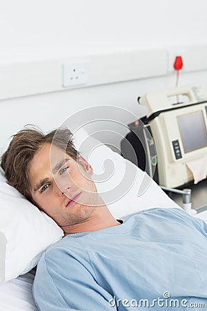 Sick man lying in hospital bed Stock Photo