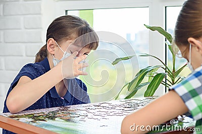 A sick masked girl scratches her eyes with dirty fingers Stock Photo