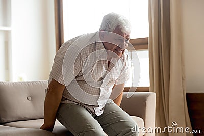 Unhealthy senior man suffer from rheumatism at home Stock Photo
