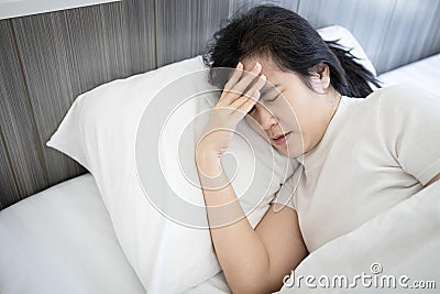 Sick middle aged woman suffering from bad migraine headache stay in bed,migraine attack in the morning,problems of chronic Stock Photo