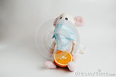 Sick mouse in a mask with an orange on a white background Stock Photo