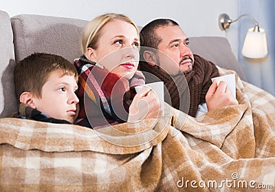 Sick parents and son under blanket Stock Photo