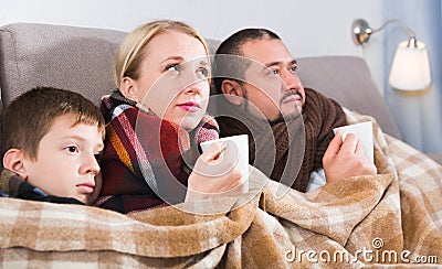 Sick parents and son under blanket Stock Photo