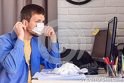 A sick quarantined man works at a computer Stock Photo