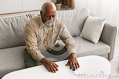 Sick Senior African Man Using Pulse Oximeter Measuring Saturation Indoor Stock Photo