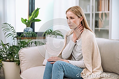 Sick upset woman touching neck and having painful sensations Stock Photo