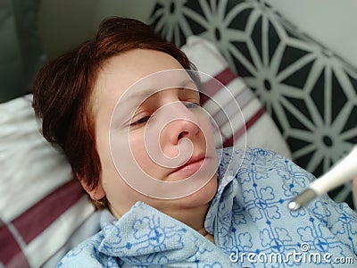 Sick woman in bed. Headache, runny nose and cold. Paleness of the face and faintness of the body. Feeling unwell. The Stock Photo