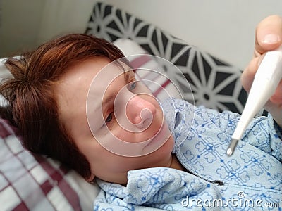Sick woman in bed. Headache, runny nose and cold. Paleness of the face and faintness of the body. Feeling unwell. The Stock Photo