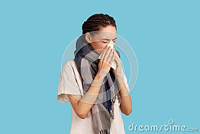 Sick woman feels unwell, blows nose in tissue, suffers from running nose, cold symptoms, allergy Stock Photo