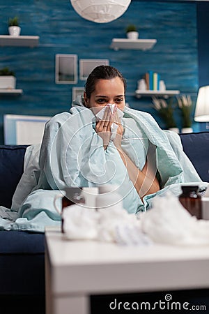 Sick woman wrapped in blanket at home with virus infection Stock Photo