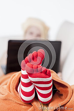 Sick women in funny toesocks on couch Stock Photo