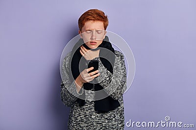 Sick young unhappy poor man standing on blue background calling doctor Stock Photo
