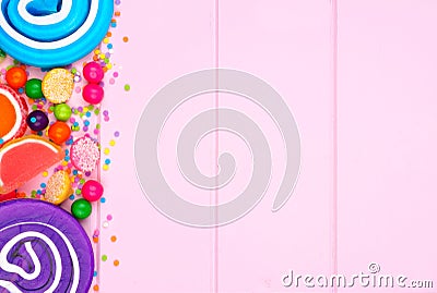 Side border of assorted colorful candies against pink wood Stock Photo