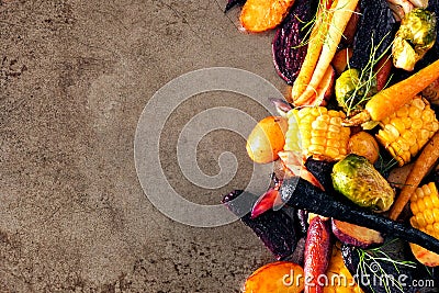 Side border of colorful roasted autumn vegetables on a rustic baking tray background Stock Photo