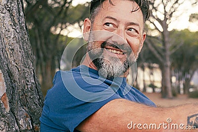 Side closeup portrait of adult man with beard smiling and enjoying relax time at the park. Happy and serene people with cheerful Stock Photo
