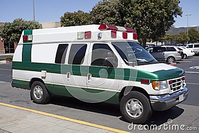 Side and front view of parked green and white ambulance Stock Photo