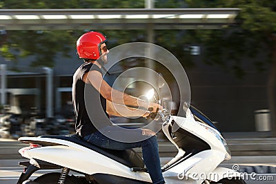 Side of handsome smiling man on motorcycle ride in city Stock Photo