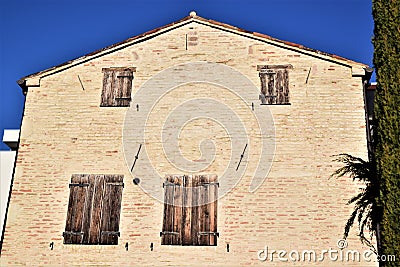 Side of one, simple but made interesting by the patina of the time, house with wooden shutters in Padua. Stock Photo