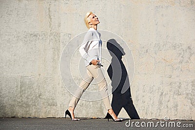 Side portrait of a cheerful young woman walking outside Stock Photo