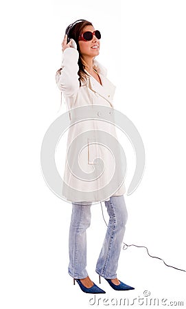 Side pose of standing model listening music Stock Photo