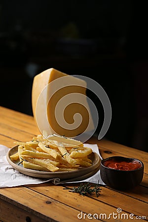 A side of potato fries with tomato sauce and cheese. Stock Photo