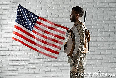 Side view of American soldier near national flag. Stock Photo