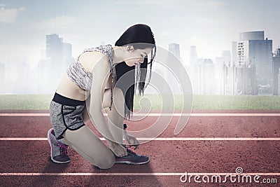 Beautiful Asian woman tying her shoestrings Stock Photo