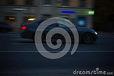 Side view of black bmw 320d F30 model driving on the road. Night traffic scene Editorial Stock Photo